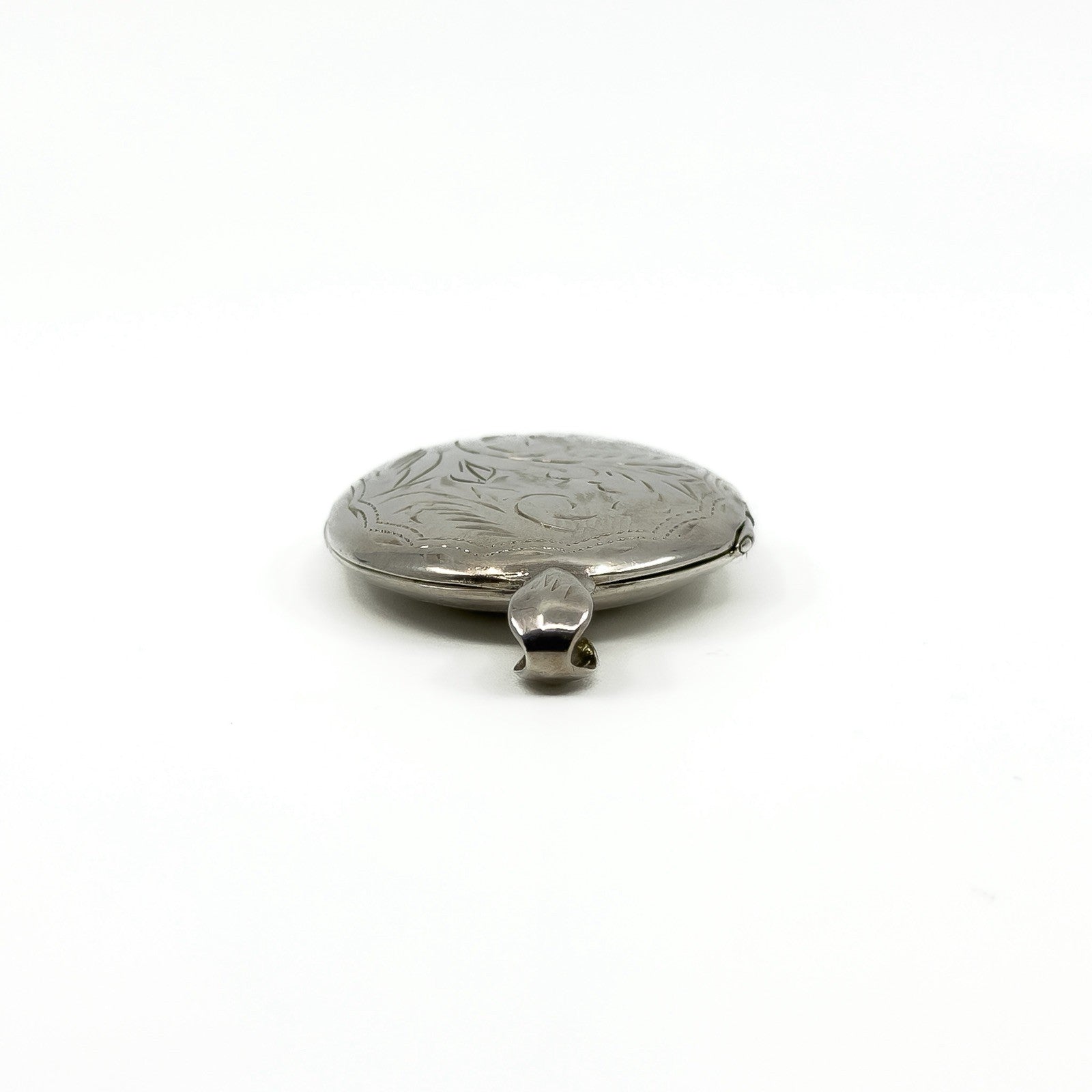 Low side view of the sterling silver engraved oval locket showing the rounded edge