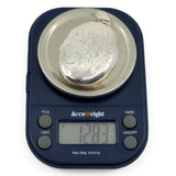 Vintage sterling silver oval engraved photo locket shown weighing 12.83g on digital scales