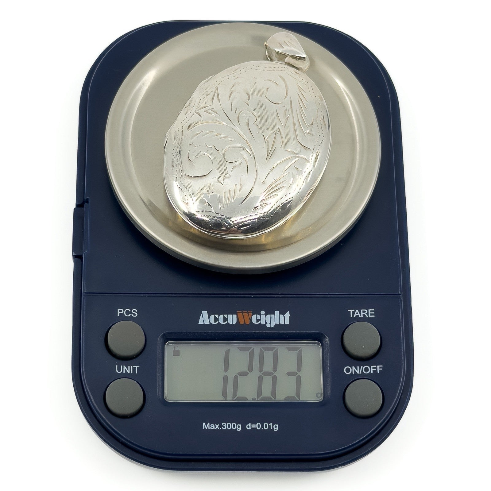 Vintage sterling silver oval engraved photo locket shown weighing 12.83g on digital scales