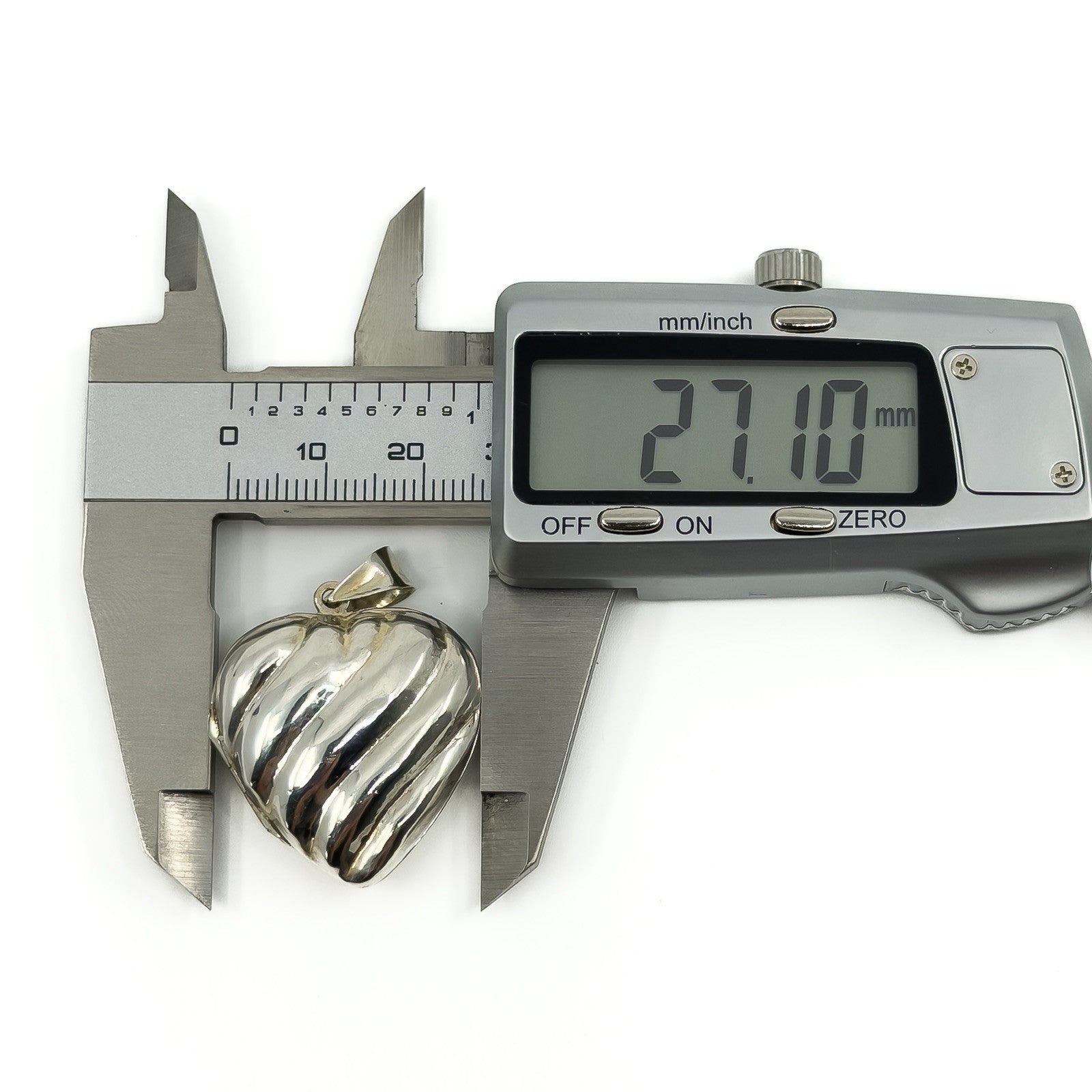 Digital calipers measuring the puffy heart sterling silver locket at approximately 27.1mm wide