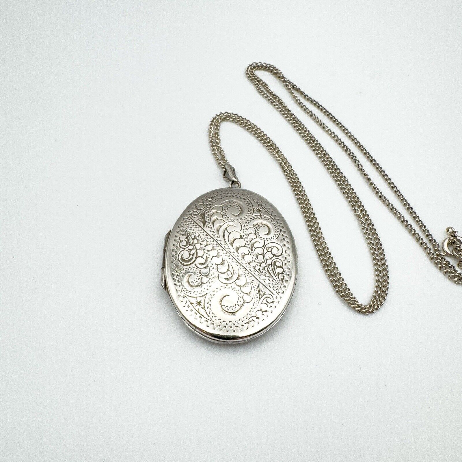 Engraved vintage oval locket shown on 24 inch curb chain