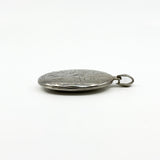 Side profile of a sterling silver oval photo locket showing its chunky depth and bail