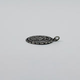 Side view of sterling silver St Christopher pendant charm showing the textured edge and jump ring.