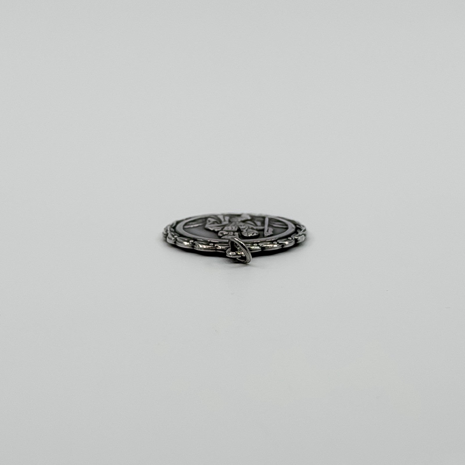 Side view of vintage sterling silver St Christopher pendant charm showing the jump ring fitting.
