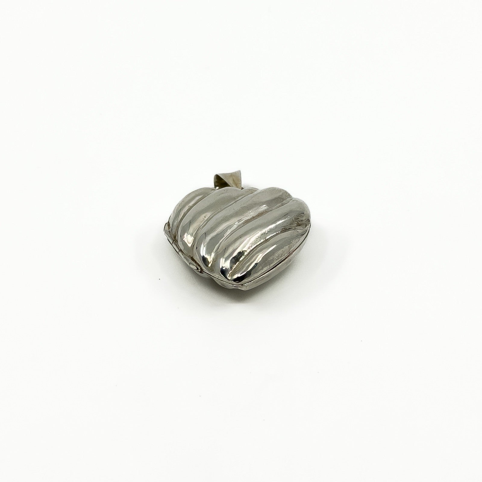 Angled view of the vintage sterling silver puffy heart locket with polished ridged front.