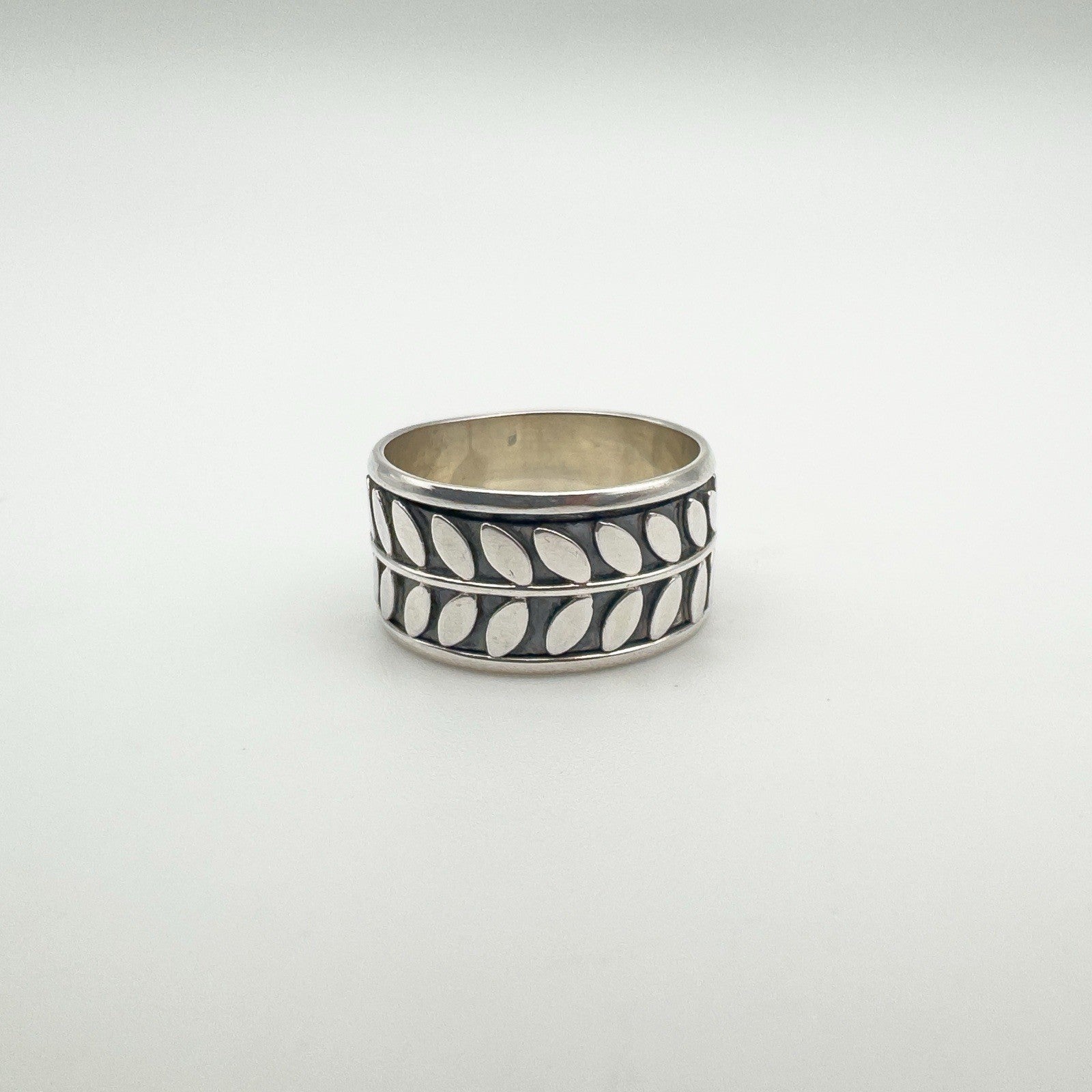 Sterling silver band ring with repeating leaf motif design