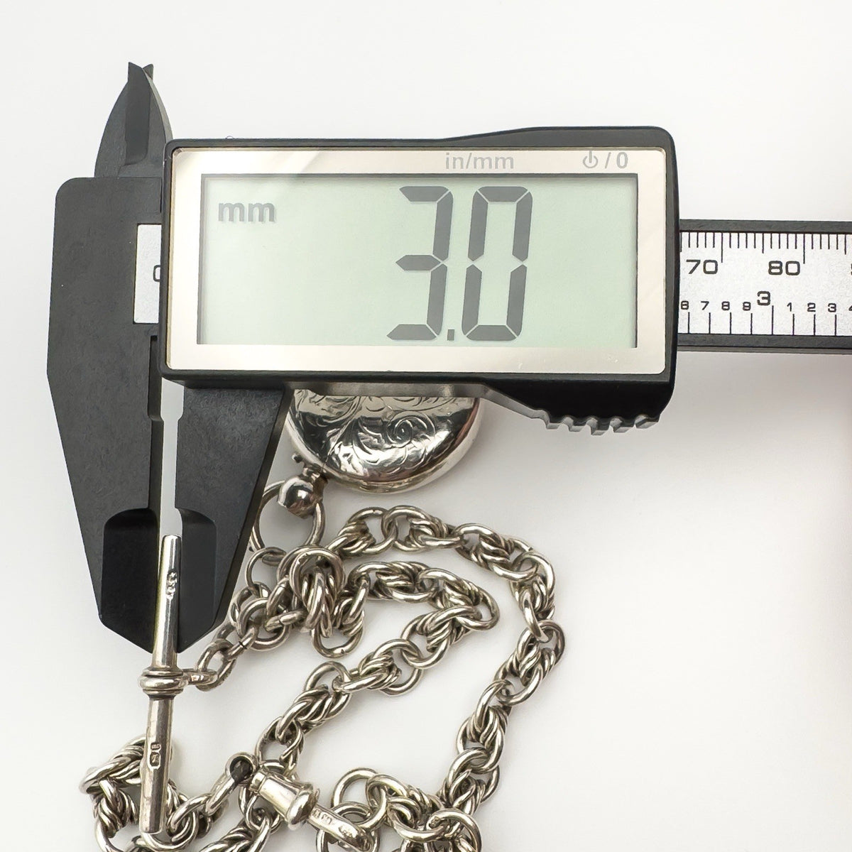 Caliper measuring T-bar width of antique silver Albert chain at 3.0mm