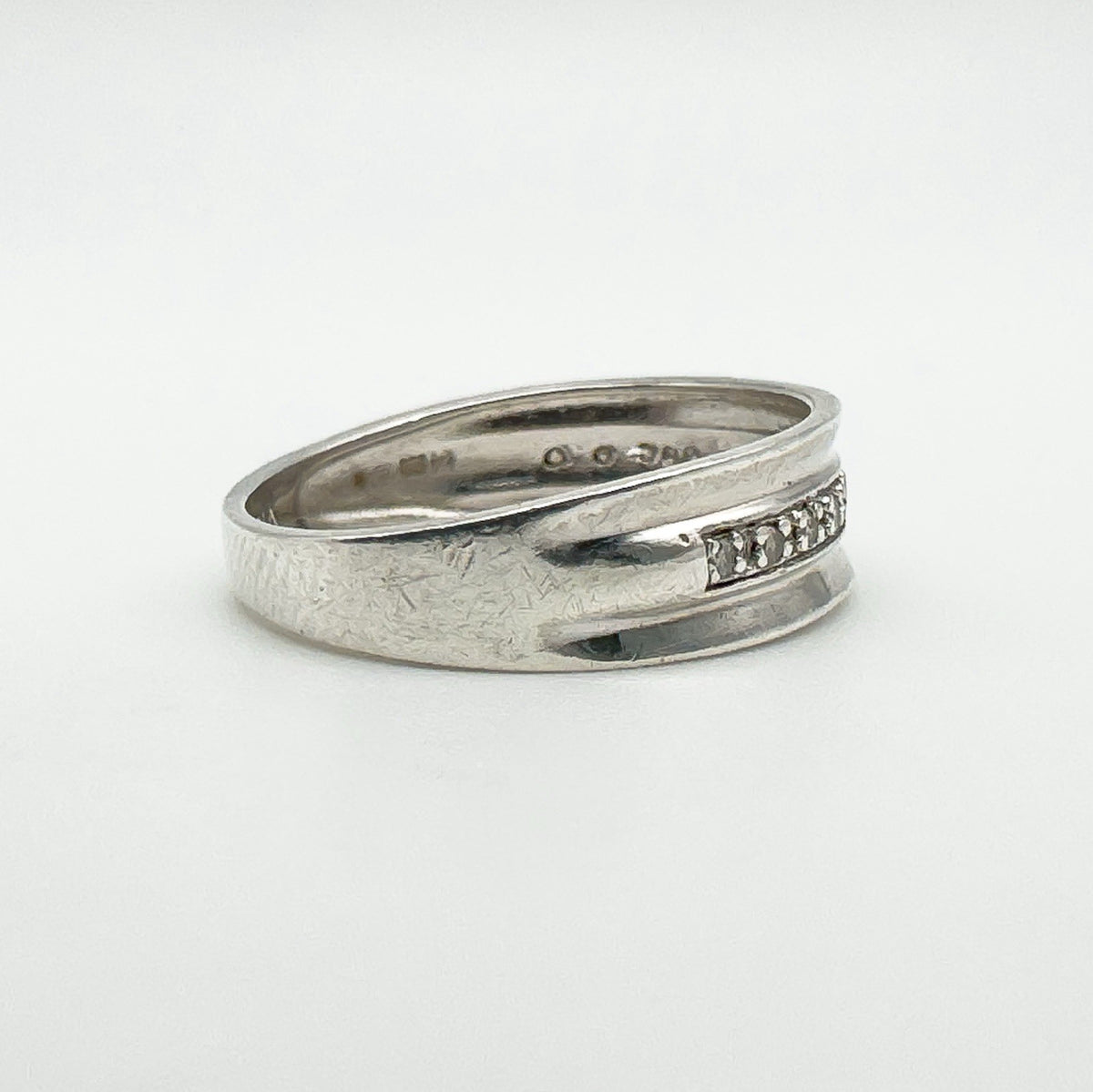 Tapered view of sterling silver ring with natural diamonds in flush setting