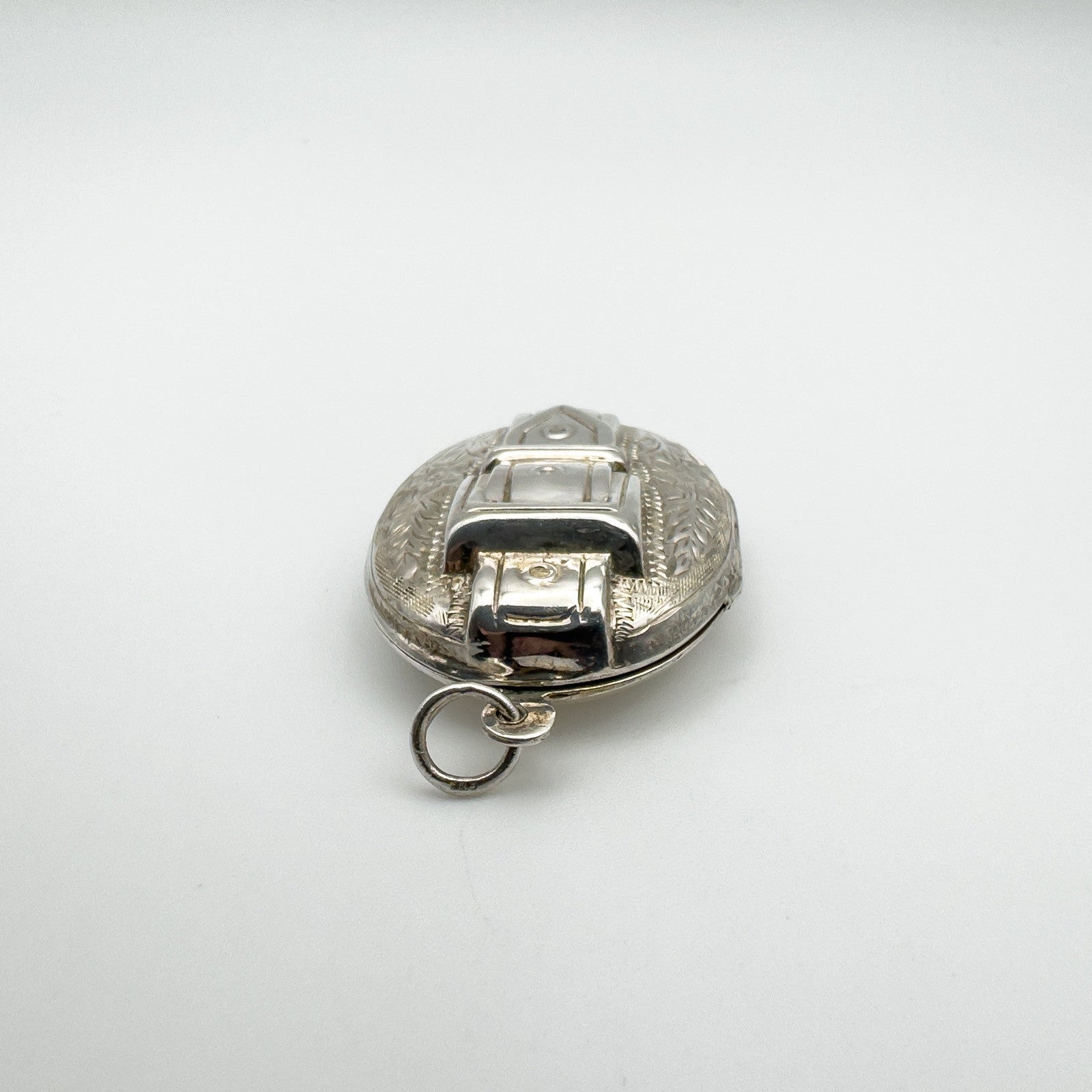 Close-up of locket top loop and raised buckle motif