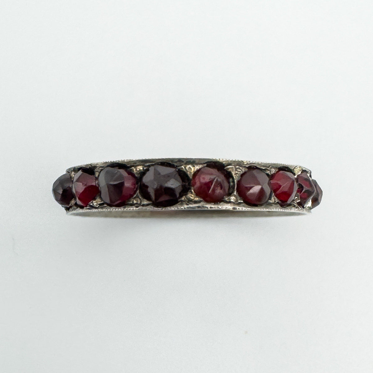 Close-up top view of vintage Bohemian garnet eternity ring in sterling silver