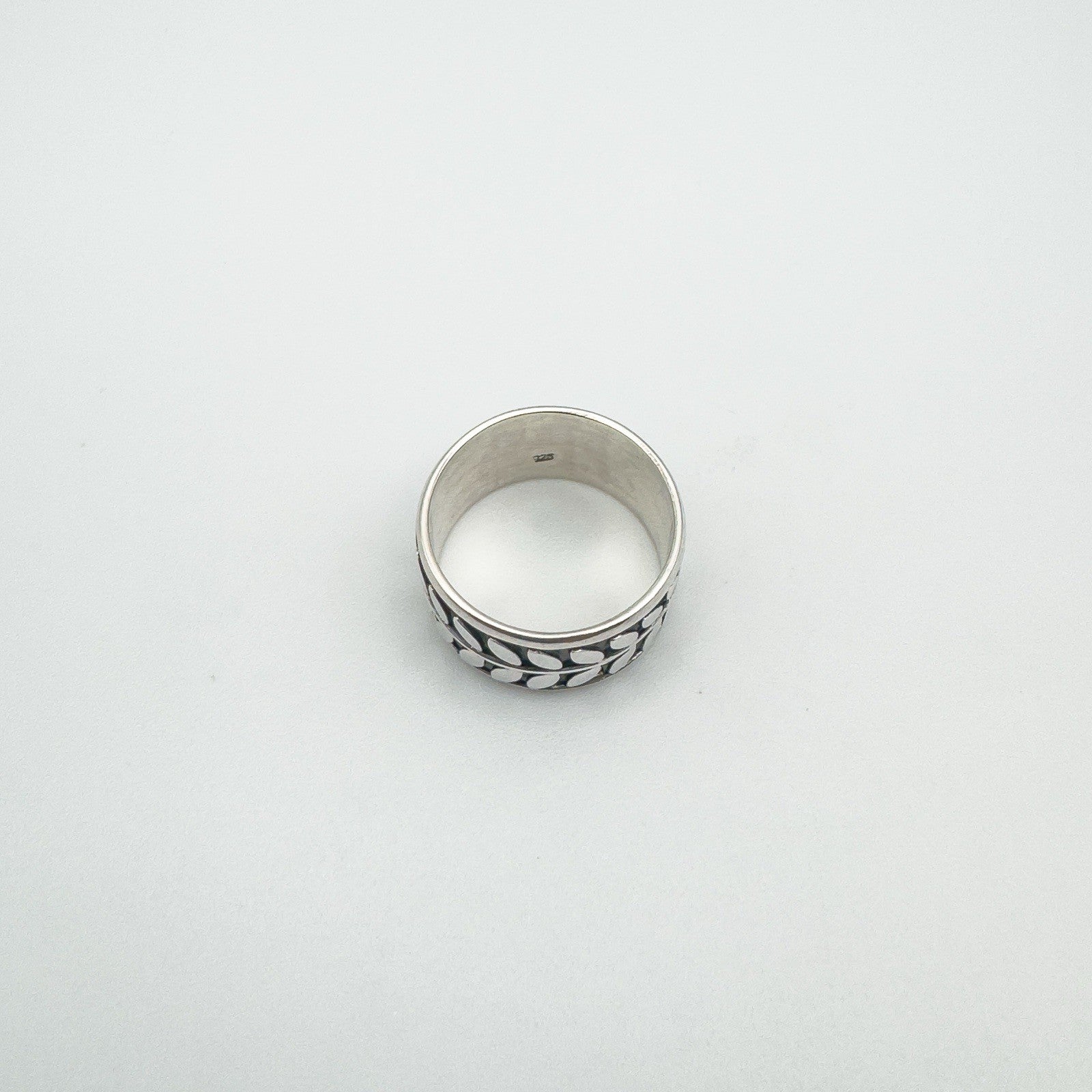 Top view of sterling silver band ring with rotating leaf design