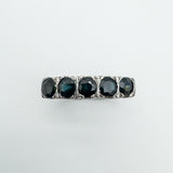 Overhead view of five flush-set sapphires in a vintage sterling silver band