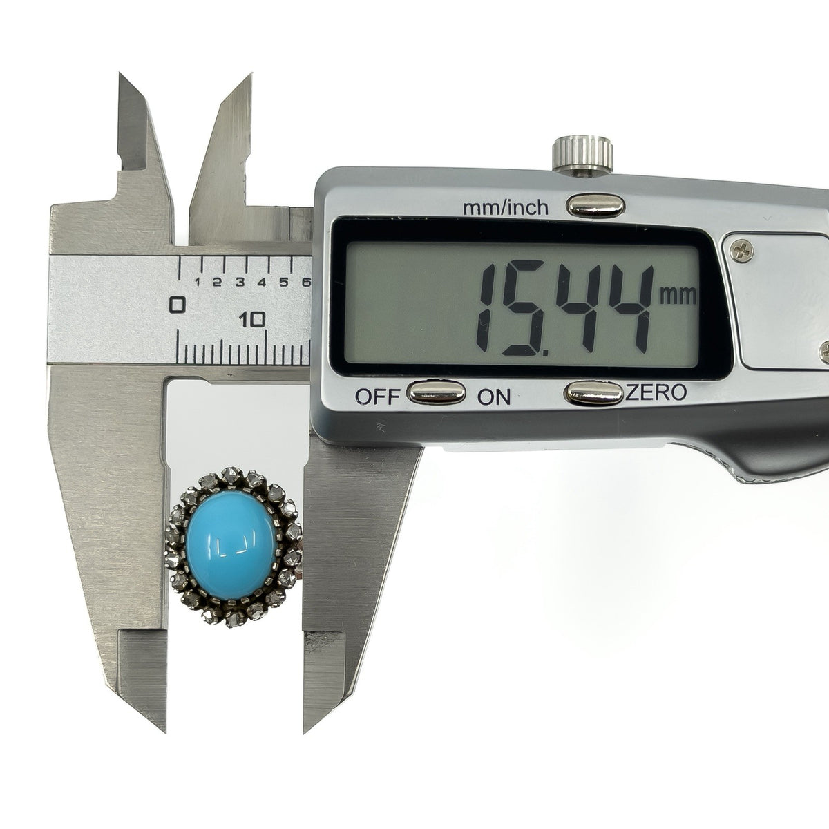 Calipers showing the turquoise and diamond halo ring head width measuring approximately 15.4mm