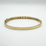 Back view of gemstone settings on vintage gold emerald bangle
