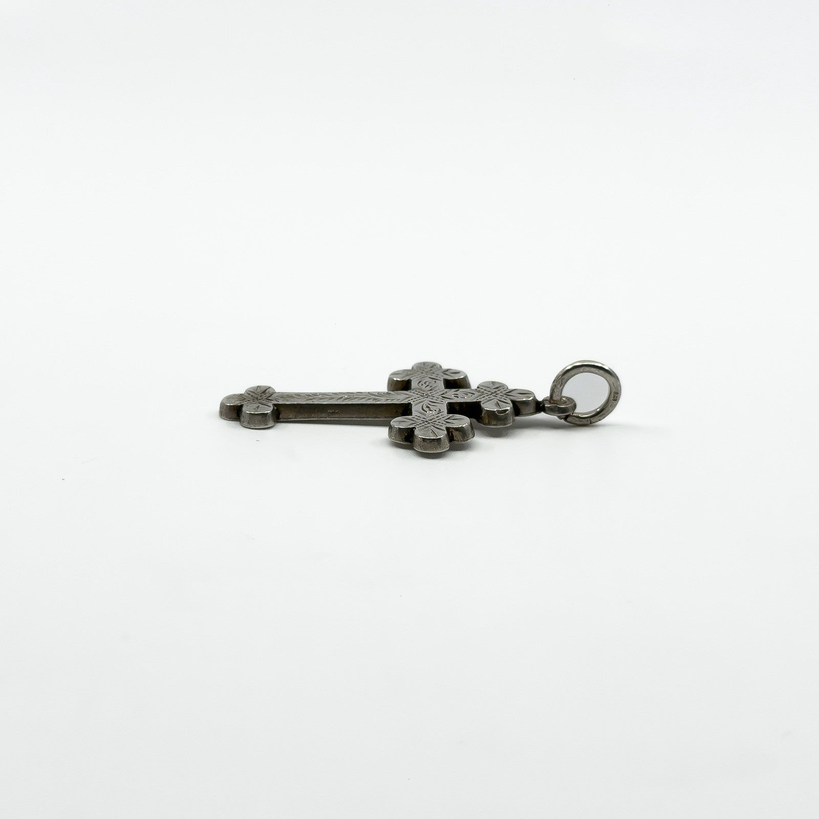 Side profile of Victorian sterling silver cross pendant showing engraved front and large bail