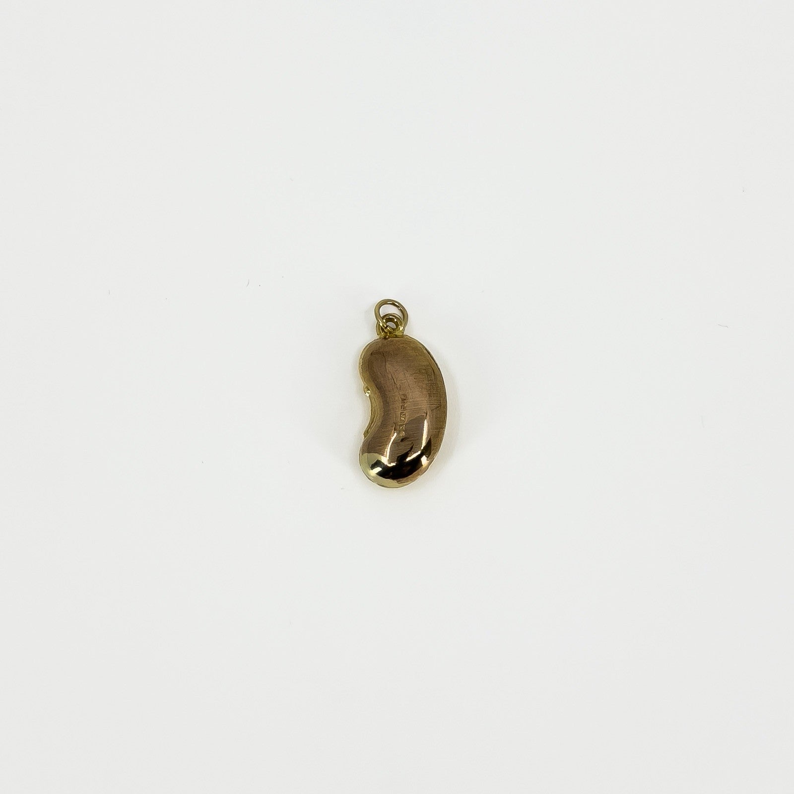 Reverse view of vintage 9ct gold lucky bean charm pendant showing its polished surface and suspension hoop.