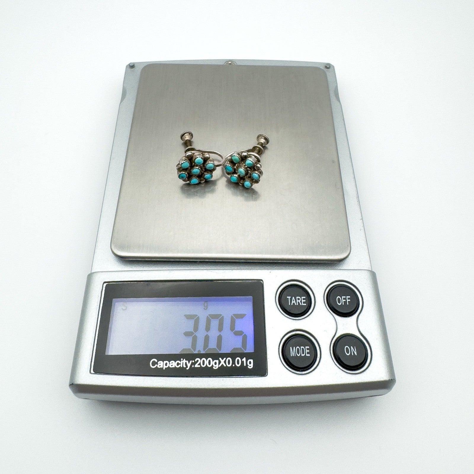Turquoise screw back earrings on digital scale showing weight of 3.05 grams