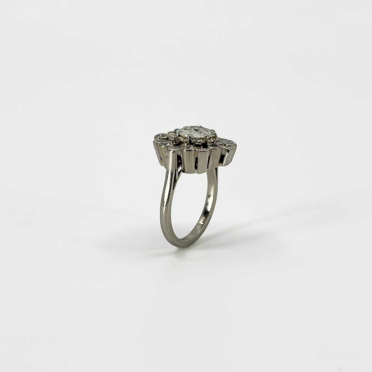 Side profile of vintage platinum diamond cluster ring showing the elevated cluster setting and platinum band.