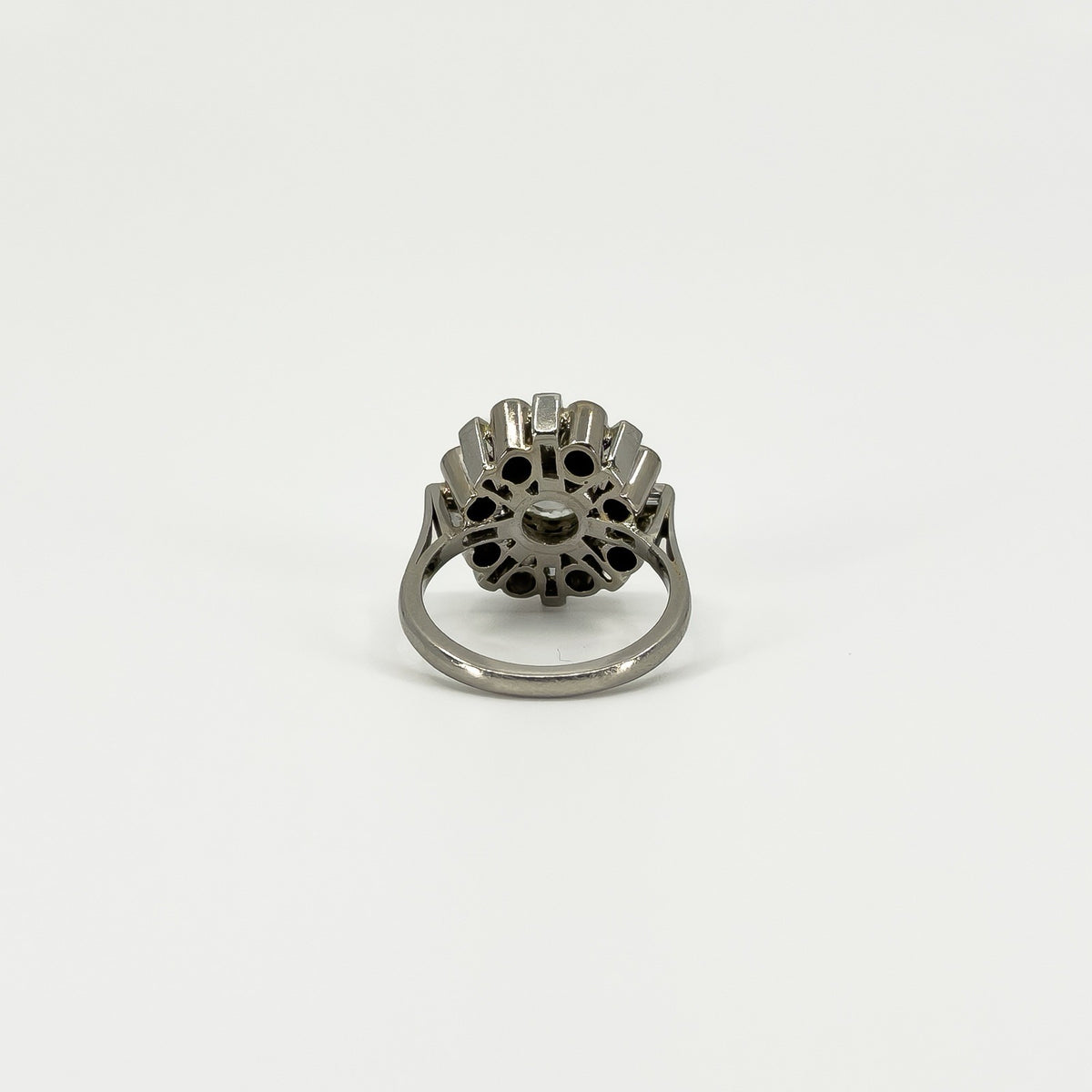 Underside of vintage platinum diamond cluster ring showing the open-backed gallery and platinum band.