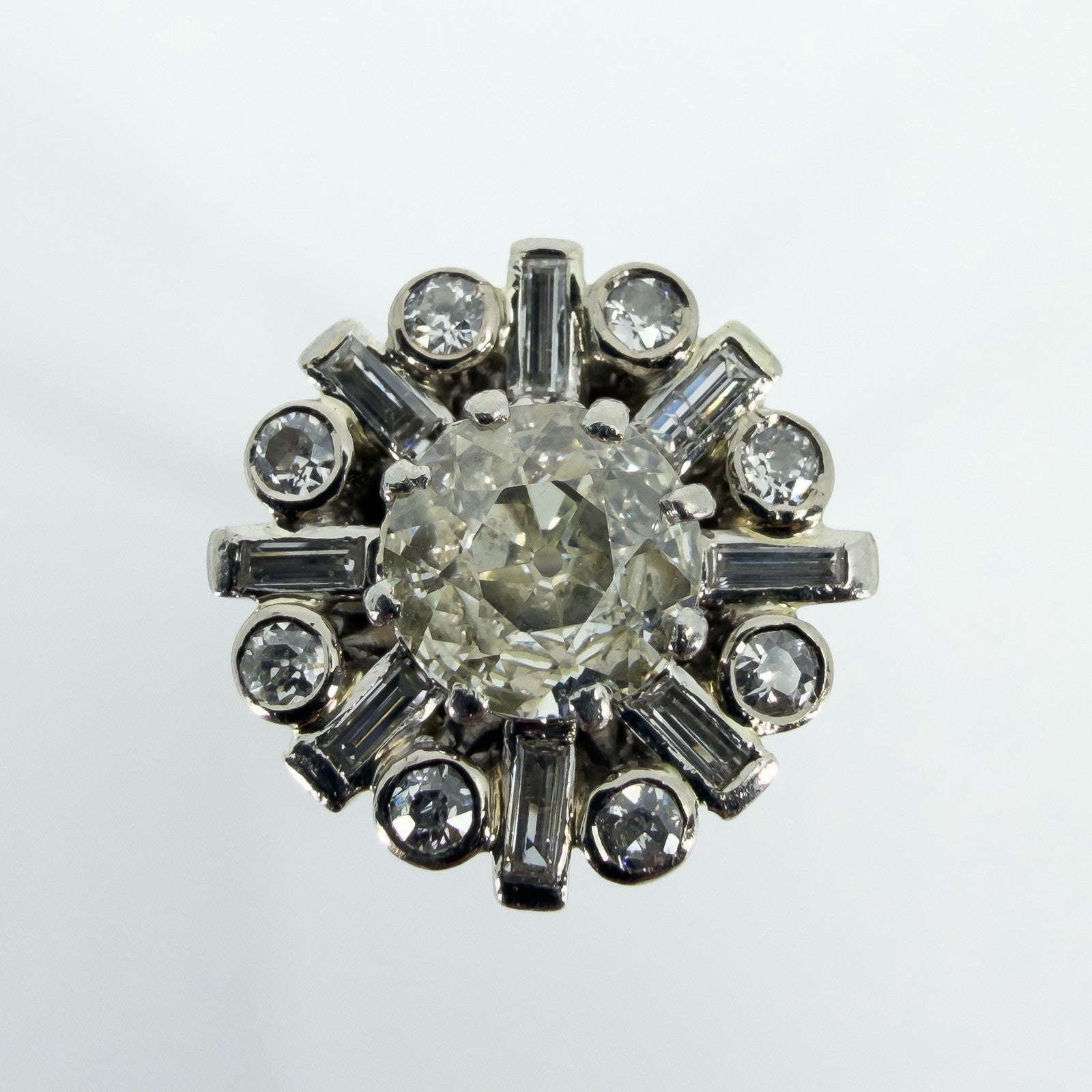 Close-up of vintage platinum cluster ring with 1.50ct estimated old cut centre and surrounding diamonds.