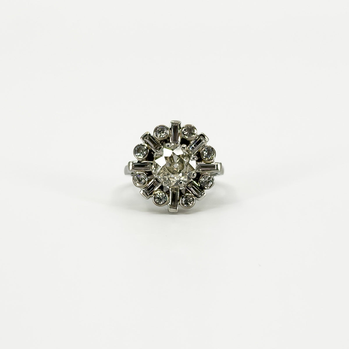 Vintage platinum diamond cluster ring with 1.50ct estimated old cut centre and geometric diamond surround.