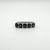 Close-up of vintage sterling silver ring with five dark blue sapphires in a claw setting