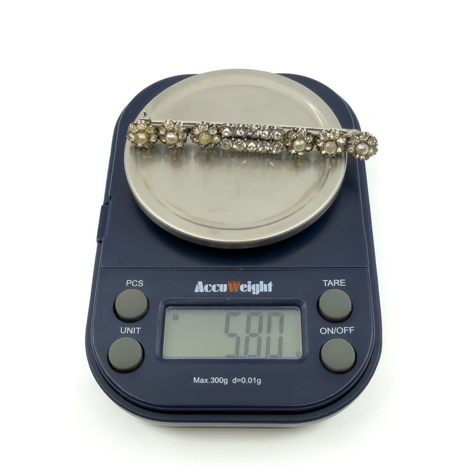 Antique sterling silver paste and pearl bar brooch on scales showing approx 5.80g.