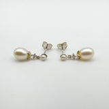 Side view of sterling silver pearl earrings with CZ lying flat