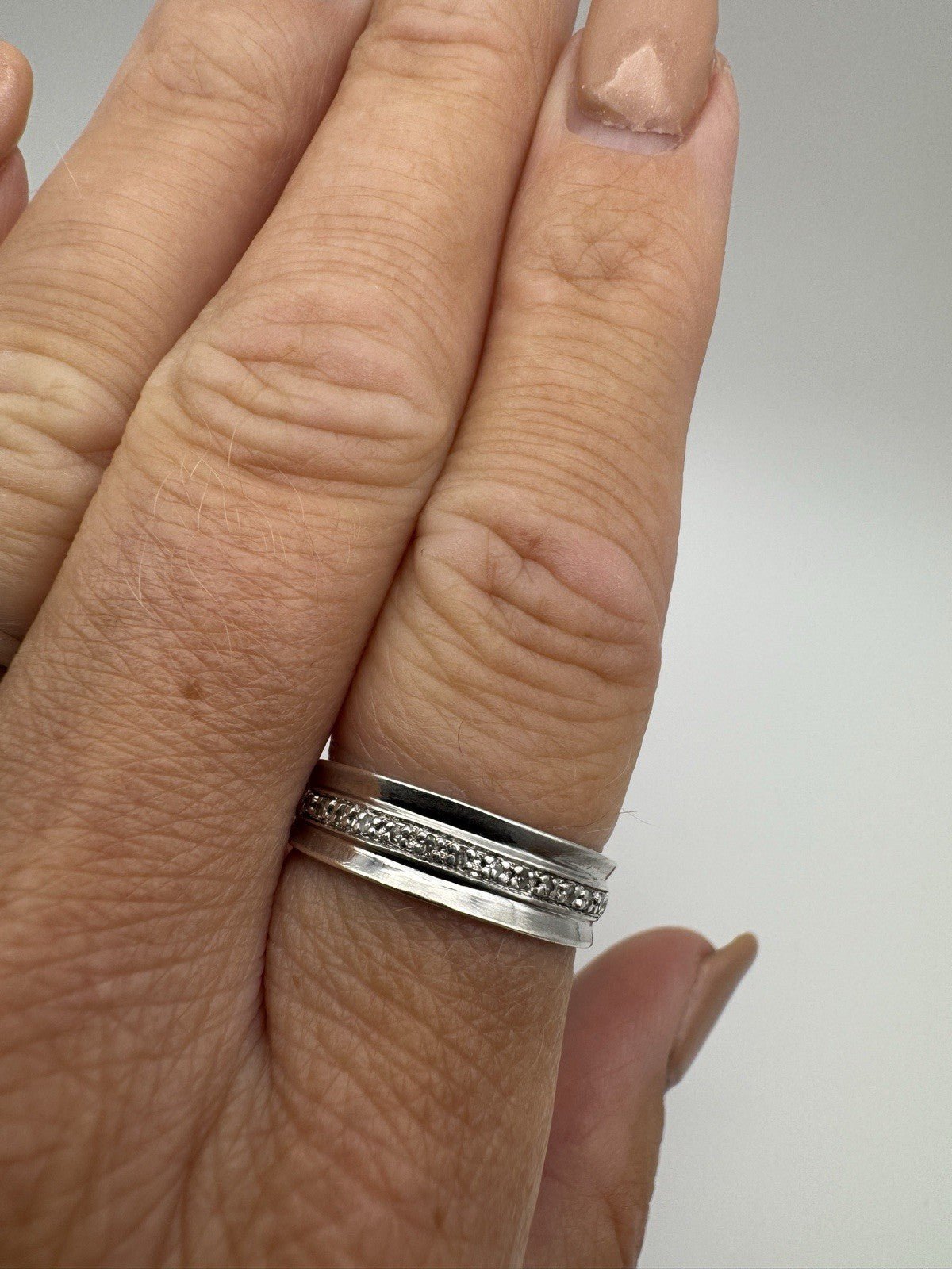 Preloved sterling silver diamond ring worn on finger, showing full front detail
