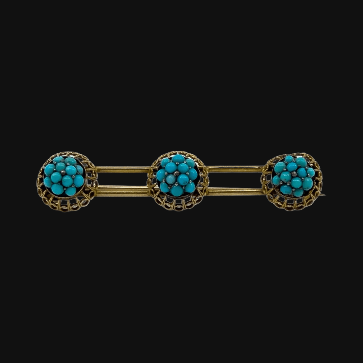 Antique gold and turquoise three-cluster bar brooch on black background