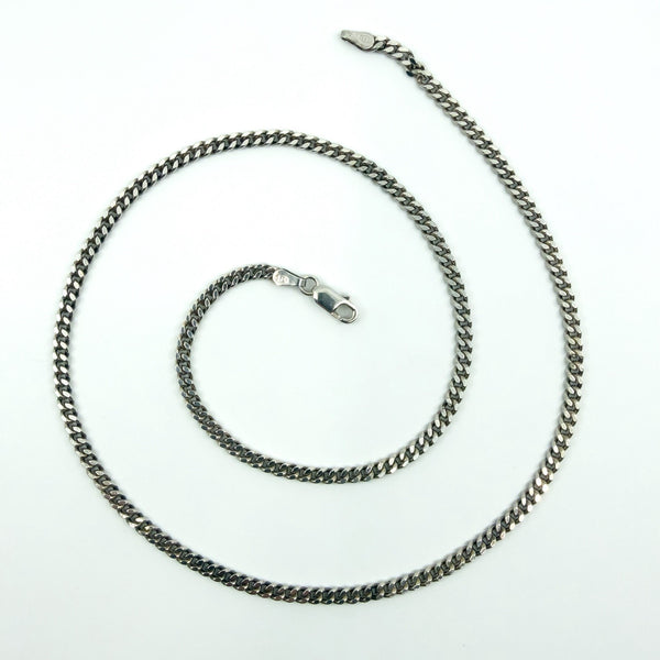 Sterling silver 18 inch flat curb chain laid out in a spiral, with lobster clasp and 925 stamp.