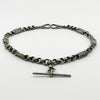 Angled view of an antique Victorian sterling silver Albert chain with faceted links and pierced bar sections