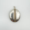 Angled view of vintage silver photo locket showing engraved design and depth