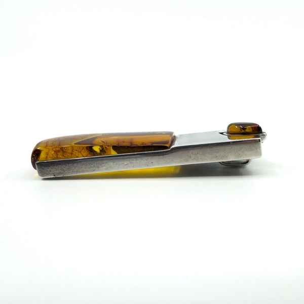 Side profile of amber and sterling silver pendant showing the long amber section.