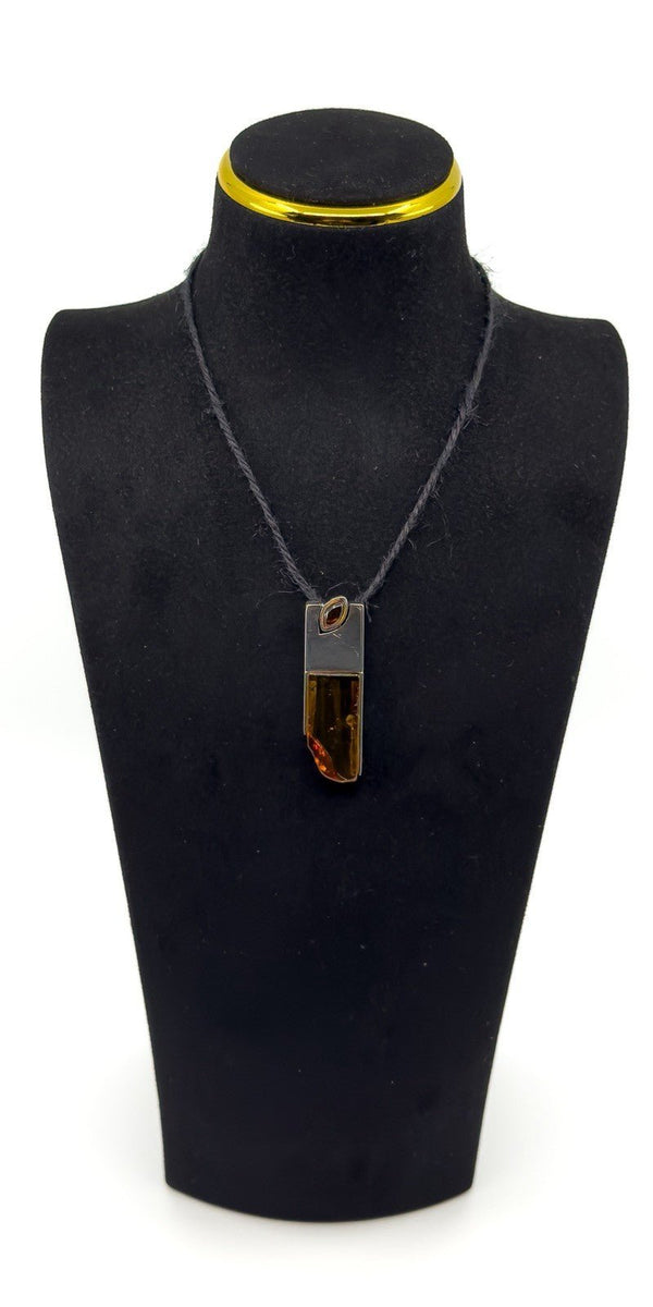 Amber and sterling silver pendant shown on a black display bust.