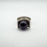 Bold amethyst ball nestled in modernist sterling silver ring, full front angle