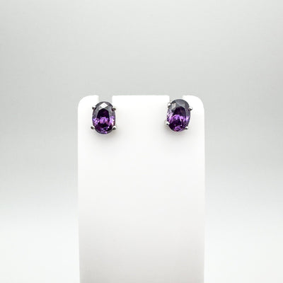 Amethyst solitaire stud earrings shown on white display card
