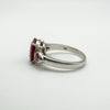 Side angle showing hallmark and deep ruby setting on silver band