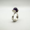 Angled view of sterling silver modernist ring with round amethyst ball