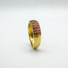 Angled close-up of pink and red ruby stones in gold-plated setting