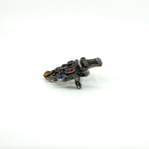 Angled view of giardinetti basket brooch with marcasites and bright multicoloured paste stones set in silver.