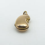 Side angled image of vintage 18ct gold kidney bean charm with curved surface
