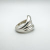 Angled shot showing sculptural curves of sterling silver wrap over ring