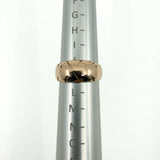 Antique 12ct rose gold band ring shown on a ring mandrel for sizing reference