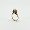 Angled upright view of the antique 14ct rose gold ring showing the height and decorative diamond setting.