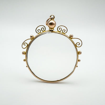 Antique 9ct gold locket pendant with ornate scrollwork and clear double-sided glass.