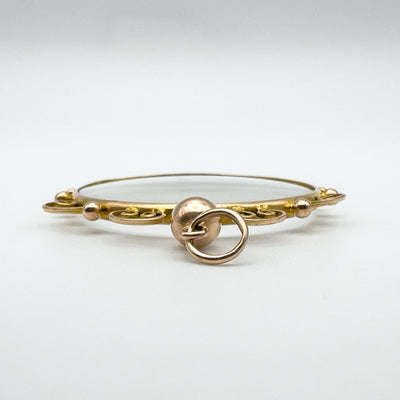 Side view of closed 9ct gold locket pendant with glass panels and bail detail.