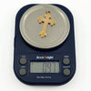 Antique 9ct rose gold cross pendant shown on weighing scales at approximately 0.9g