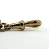 Close up of the 9c stamp on the dog clip of an antique rose gold bracelet