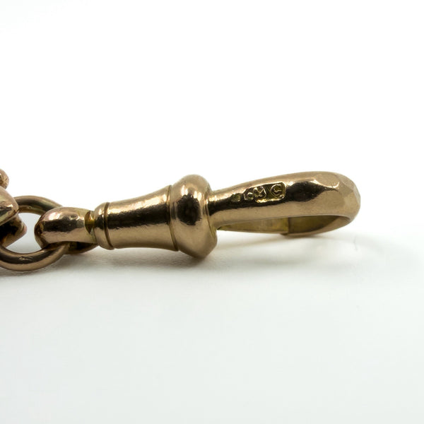 Close up of the 9c stamp on the dog clip of an antique rose gold bracelet